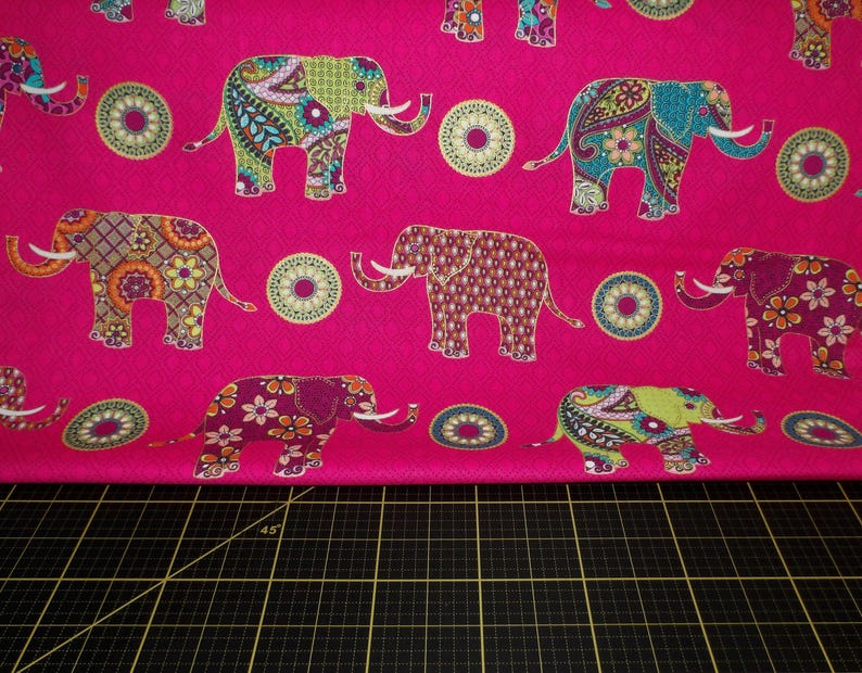 Puede incluir: Una tela rosa vibrante con un patr&oacute;n repetido de elefantes coloridos y dise&ntilde;os circulares. Los elefantes est&aacute;n adornados con intrincados patrones en tonos verdes, azules, naranjas y morados.