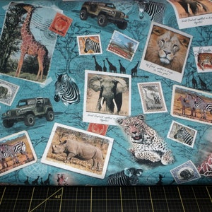 May include: Teal fabric featuring a collage of safari animals and vintage postage stamps. The design includes giraffes, zebras, elephants, lions, and leopards, along with miniature jeeps, all set against a map-like background.