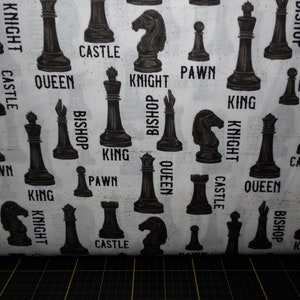 May include: White fabric with a repeating pattern of black chess pieces. The pieces include a king, queen, bishop, knight, rook, and pawn. The names of each piece are printed below the image.