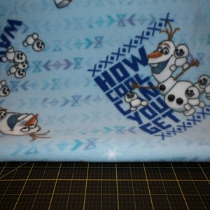 May include: Blue fleece fabric with a white snowman and the text "How cool can you get".