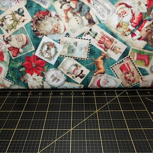 May include: A teal fabric with a repeating pattern of vintage Christmas cards. The cards feature images of snowmen, reindeer, Santa Claus, and other festive imagery. The fabric is ideal for crafting projects, quilting, and other creative pursuits.