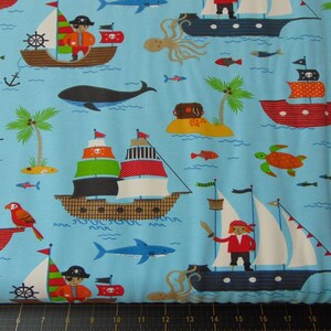 May include: Blue fabric with a repeating pattern of pirate ships, parrots, fish, and islands. The ships have red, white, and black sails and are decorated with flags and skulls. The parrots are red and green. The fish are blue and orange. The islands are green and brown.