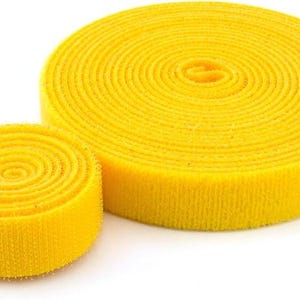 Op de afbeelding: Twee rollen gele klittenband. De grotere rol is volledig opgerold en de kleinere rol is gedeeltelijk opgerold.