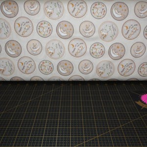 Clothworks. GHMILY 2024. Badges Light Caramel - Guess How Much I Love You Fabric