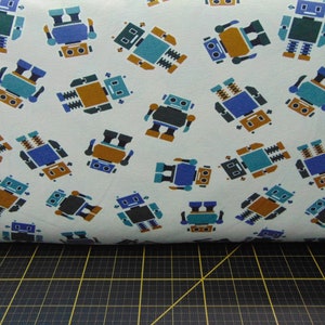 Peut inclure: Tissu blanc avec un motif répété de robots bleus, verts et bruns. Les robots ont des formes et des tailles différentes.