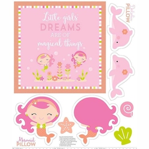 Könnte beinhalten: Ein rosa-grünes Stoffpanel mit einem Meerjungfrauen- und Delfin-Kissenmuster. Das Panel zeigt den Text "Little girls' DREAMS ARE OF magical things." und enthält Anweisungen zum Nähen von Kissen.