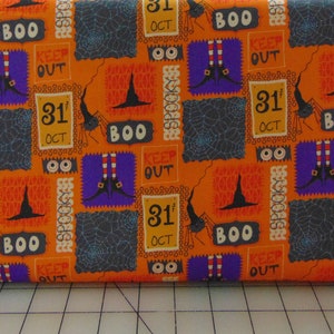 Peut inclure: Tissu orange avec un imprimé d'Halloween représentant des jambes de sorcières, des araignées, des chapeaux de sorcières et le texte "BOO" et "31st OCT".