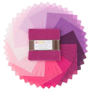 Puede incluir: Una colección de 42 cuadrados Charm Squares de Kona Cotton Solids en un degradado de tonos rosas, morados y rojos. Los cuadrados miden 5 pulgadas por 5 pulgadas y están dispuestos en un patrón circular. La etiqueta dice "Kona Cotton Solids Charm Squares" y "Robert Kaufman Fabrics".