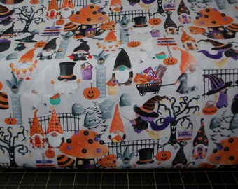 May include: A white fabric with a repeating pattern of gnomes, pumpkins, candy, and Halloween-themed imagery. The fabric features a variety of colors, including orange, black, green, and purple.