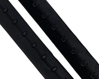 May include: Two black elastic bra straps with metal hooks. The straps are about 1 inch wide and have a velvet-like texture.