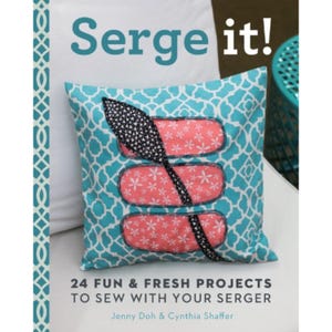 May include: A book titled "Serge it!" with a turquoise and white patterned cushion on the cover. The book title is in a bold, blue font. The subtitle is "24 Fun & Fresh Projects to Sew with Your Serger". The authors are listed as Jenny Doh & Cynthia Shaffer.