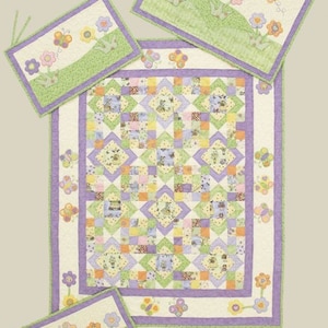 Op de afbeelding: Een set van vier gestikte wiegbumper met een bloemen- en vlinderthema. De bumpers zijn in tinten groen, paars, geel en wit. De stof heeft een patchwork-ontwerp met kleine vierkanten en een rand van vlinders en bloemen.