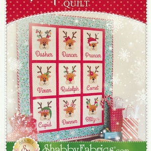 Pode incluir: Um padrão de colcha com Rudolph e seus amigos renas. A colcha é composta por nove quadrados, cada um com uma rena diferente. As renas usam todas chapéus festivos e têm chifres. A colcha é cercada por uma borda de bolinhas vermelhas e brancas. O texto "Rudolph and Friends Quilt" está escrito em vermelho e branco na parte superior da imagem.