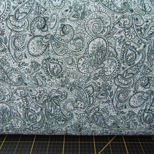 May include: White fabric with a dark green paisley pattern.