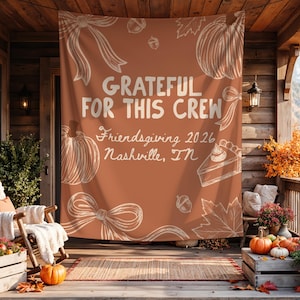 K&ouml;nnte beinhalten: Ein Hintergrund aus rostorangefarbenem Stoff mit wei&szlig;en Linienzeichnungen von K&uuml;rbissen, Eicheln, Bl&auml;ttern und Schleifen. Der Text lautet: GRATEFUL FOR THIS CREW, Friendsgiving 2026, Nashville, TN. Ein rechteckiges Banner.