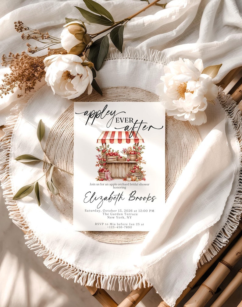 Puede incluir: Una tarjeta de invitaci&oacute;n rectangular blanca con el texto "appley EVER after" en letra cursiva negra sobre una ilustraci&oacute;n en acuarela de un puesto de manzanas a rayas rojas y blancas. La tarjeta incluye los detalles de una despedida de soltera.