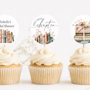 May include: Three cupcakes topped with circular paper toppers. The first reads Michelle's Bridal Shower above a stack of books. The second says Her Next Chapter above books and flowers. The third features a stack of books tied with a ribbon.
