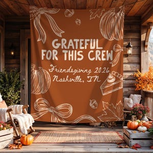 K&ouml;nnte beinhalten: Ein rechteckiges Banner aus rostorangefarbenem Stoff mit wei&szlig;en Strichzeichnungen von K&uuml;rbissen, Schleifen, Eicheln, Bl&auml;ttern und einem St&uuml;ck Kuchen. Der Text lautet: GRATEFUL FOR THIS CREW, Friendsgiving 2026, Nashville, TN.