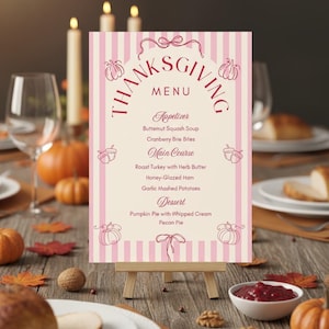 Pu&ograve; includere: Menu del Ringraziamento su un piccolo cavalletto di legno. Il menu presenta uno sfondo a righe rosa e bianche con la parola "Thanksgiving" in un design circolare. Il menu elenca antipasti, piatti principali e dessert.