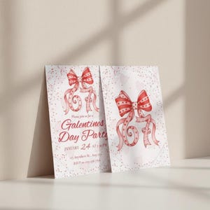 May include: Two Valentine's Day party invitations. Each card features a watercolor illustration of a red bow with patterned details and flowing ribbons. The text on the card reads "Galentines Day Party" and includes the date and time.
