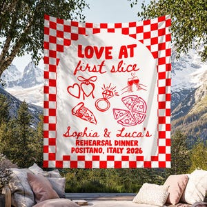 May include: A white rectangular tapestry with a red and white checkered border. The center features red line art of hearts, a diamond ring, wine glasses, and pizza slices. Text reads: LOVE AT first slice, Sophia & Luca's REHEARSAL DINNER POSITANO, ITALY 2026.