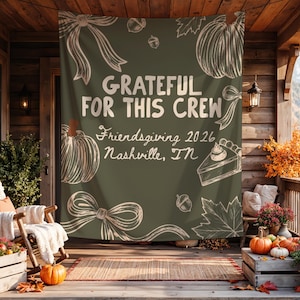 K&ouml;nnte beinhalten: Ein olivgr&uuml;nes Stoffbanner mit wei&szlig;en Strichzeichnungen von K&uuml;rbissen, Schleifen, Eicheln, Bl&auml;ttern und einem St&uuml;ck Kuchen. Der Text lautet: GRATEFUL FOR THIS CREW, Friendsgiving 2026, Nashville, TN. Das Design ist auf einem Banner zentriert.