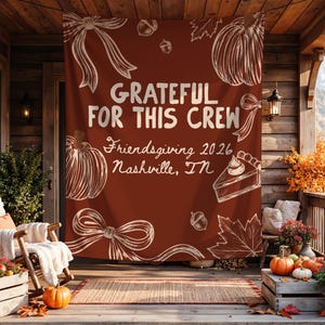 K&ouml;nnte beinhalten: Ein rechteckiges Stoffbanner in tiefem Rostorange mit wei&szlig;en Strichzeichnungen von K&uuml;rbissen, Schleifen, Eicheln, Bl&auml;ttern und einem St&uuml;ck Kuchen. Der Text lautet: GRATEFUL FOR THIS CREW, Friendsgiving 2026, Nashville, TN.