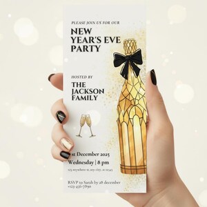 May include: A New Year's Eve party invitation held by a hand. The invitation features a champagne bottle illustration with a black bow, two champagne glasses, and event details. The text reads "New Year's Eve Party" hosted by "The Jackson Family."