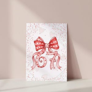 May include: A watercolor illustration of a red bow with heart patterns and ribbons. The number "67" is stylized with the ribbons. The background is white with scattered hearts and red dots, creating a romantic theme.