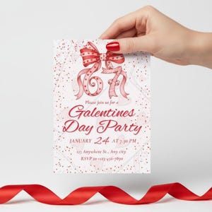May include: A Galentine's Day Party invitation card held by a hand. The card features a red bow and ribbon design with the text "Galentine's Day Party" and event details. Red confetti dots the background.