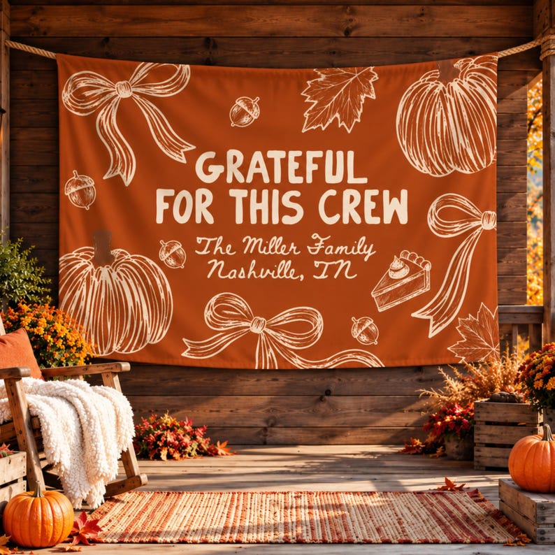 K&ouml;nnte beinhalten: Ein rechteckiges Banner aus orangefarbenem Stoff mit wei&szlig;en Strichzeichnungen von K&uuml;rbissen, Schleifen, Eicheln, Bl&auml;ttern und einem St&uuml;ck Kuchen. Der Text lautet "GRATEFUL FOR THIS CREW" sowie "The Miller Family Nashville, TN".