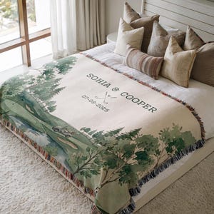 May include: A beige throw blanket with a golf course scene in green and white watercolor. The blanket has a fringe border and features the names "SOHIA & COOPER" and the date "07-08-2025".