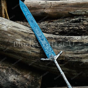 K&ouml;nnte beinhalten: Ein Fantasy-Schwert mit einer hellblauen Klinge und aufwendigen wei&szlig;en &Auml;tzmustern. Der Knauf und der Griff sind silberfarben mit detaillierten Mustern. Das Schwert wird vor dem Hintergrund verwitterter Holzst&auml;mme pr&auml;sentiert, was seine Handwerkskunst hervorhebt.