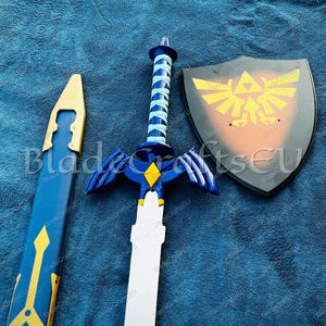 May include: A blue and white sword with a matching sheath, and a black shield with a gold emblem. The sword has a white blade, blue wings, and a blue and white handle. The shield has a gold emblem.