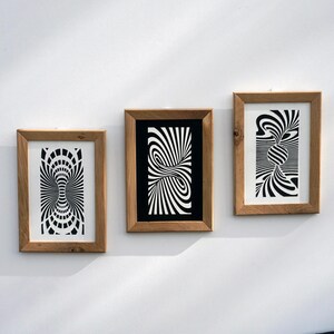 May include: Three framed art prints with black and white optical illusion designs. The wooden frames are rectangular and mounted on a white wall. The prints feature swirling, striped patterns, creating a sense of depth and movement. The artwork is modern and abstract.