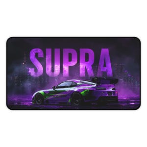 May include: A rectangular desk mat featuring a purple and green sports car in profile against a dark, foggy city skyline. The word SUPRA is printed in large, bold, purple capital letters across the upper center of the design.