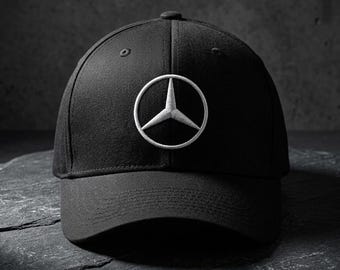 Peut inclure: Une casquette de baseball noire avec un logo étoile à trois branches Mercedes-Benz brodé en blanc au centre du panneau avant. Sous la casquette, une petite plaque rectangulaire argentée affiche le texte MERCEDES-BENZ COLLECTION en noir.