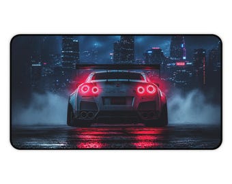 Peut inclure: Un tapis de bureau rectangulaire présentant la vue arrière d'une voiture de sport argentée avec des feux arrière circulaires rouges lumineux. Le véhicule est sur une surface sombre et humide avec du brouillard, devant un paysage urbain nocturne.
