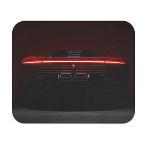 May include: A red sports car with a glowing red light bar across the rear. The car's silhouette is visible against a dark background, with the Ferrari logo centered. The image is a mousepad.