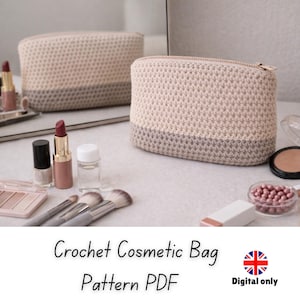 May include: Two crochet cosmetic bags in a neutral colour palette with a zip closure. The bags are beige with a grey base. Makeup brushes, lipsticks, and other cosmetic items are arranged around the bags on a white surface.