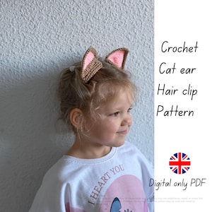 May include: A young girl wears crochet cat ear hair clips with pink inner ears. The ears are brown and attached to a hair clip. The image includes the text "Crochet Cat ear Hair clip Pattern" and "Digital only PDF".