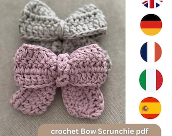 Puede incluir: Se muestran dos coleteros de lazo de ganchillo hechos a mano. Uno es de color gris claro, el otro es de color rosa empolvado. El texto "crochet Bow Scrunchie pdf pattern" está en la parte inferior de la imagen. Los coleteros están sobre un fondo neutro.