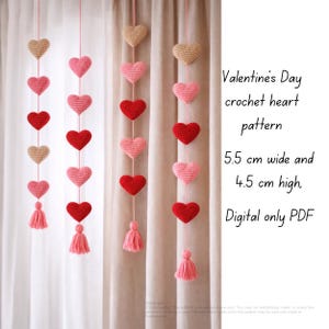 May include: A Valentine's Day crochet heart pattern. The image shows multiple strands of crocheted hearts in red, pink, and tan, each approximately 5.5 cm wide and 4.5 cm high, hanging vertically. Each strand ends with a tassel. The text on the image says "Valentine's Day crochet heart pattern".
