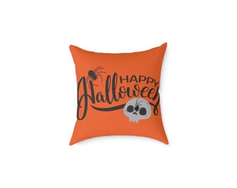 May include: An orange square pillow with a Halloween theme. The pillow features the words "Happy Halloween" in black script, along with a spider and a skull graphic. The design is centered on the pillow.