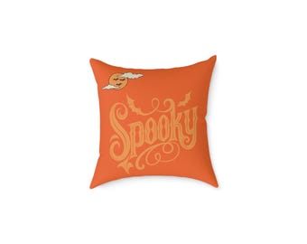 May include: Square orange pillow with the word "Spooky" in a decorative font. The pillow features a design of a full moon, bats, and clouds, perfect for Halloween decor.