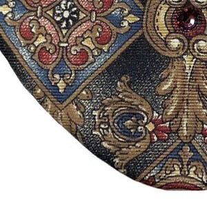 May include: A black eye patch with a gold, red and blue patterned design. The eye patch has a small, red jewel in the centre.