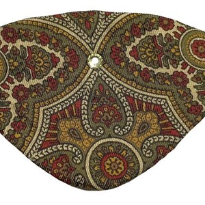 Könnte beinhalten: Ein Augenpflaster mit Paisley-Muster in Braun-, Rot- und Goldtönen. Das Augenpflaster hat einen einzelnen Strassstein in der Mitte.