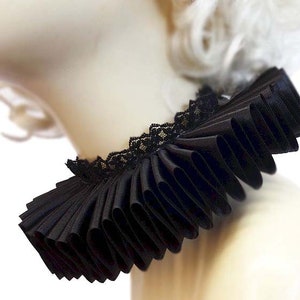 May include: A black ruffled collar with a lace trim. The collar is made of a soft, flowing fabric and is perfect for adding a touch of elegance to any outfit.