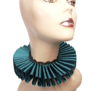 May include: Teal ruffled collar with a black lace trim. The collar is made of satin and is worn around the neck.