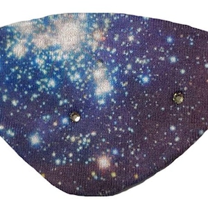 May include: A galaxy-themed eye patch with a black elastic band. The fabric features a blue, purple, and white cosmic design, embellished with three small, sparkling rhinestones. This eye patch is designed for comfort and style.
